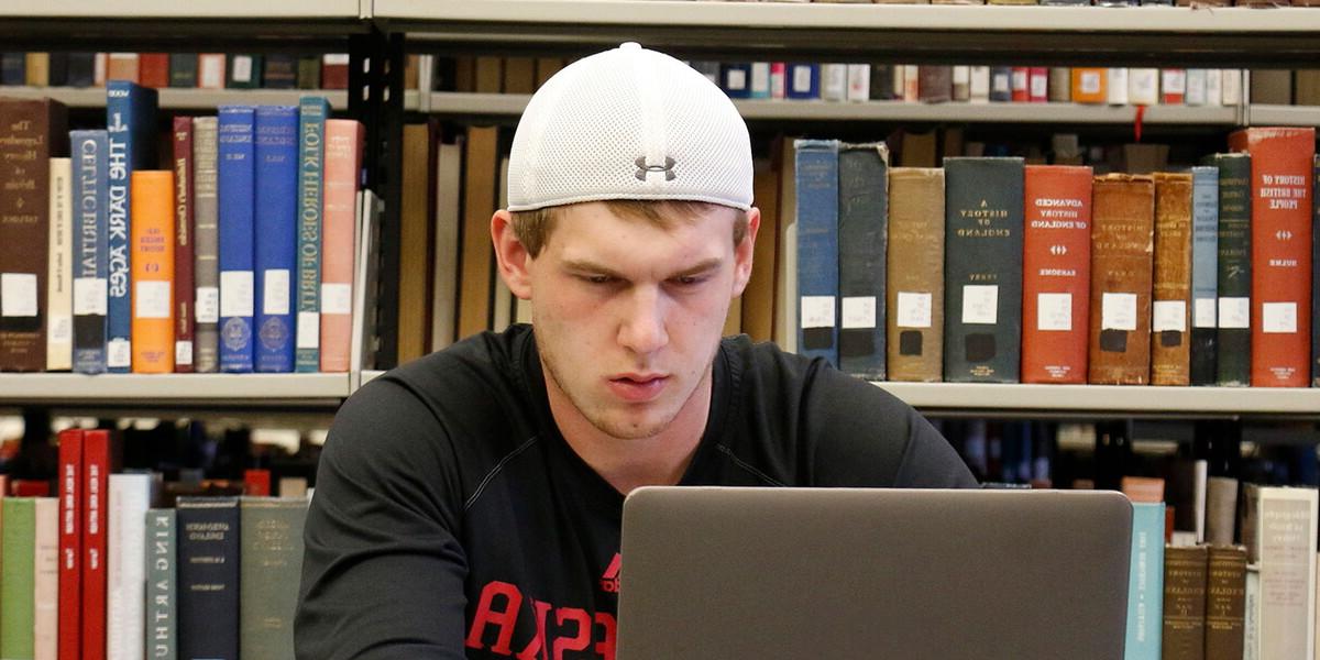 Male student in the library on a laptop