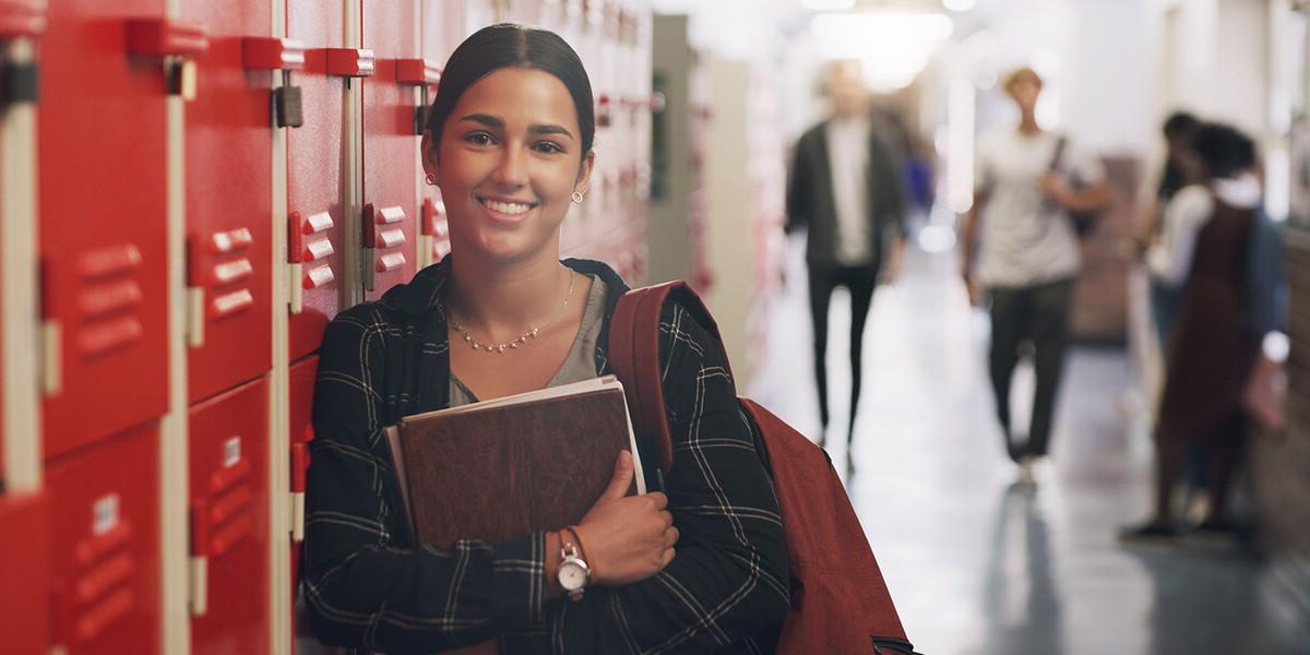 High school girl leaning against a locker
